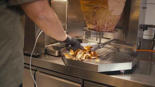 快餐店里，厨师在旋转的唾液上切烤肉串肉，视频素材模板下载