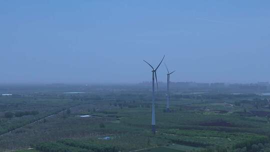 村镇城市绿色庄稼地树林风力发电大风车横移视频素材模板下载