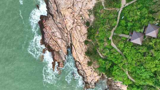 海岸边绿意盎然的山景与平静海面