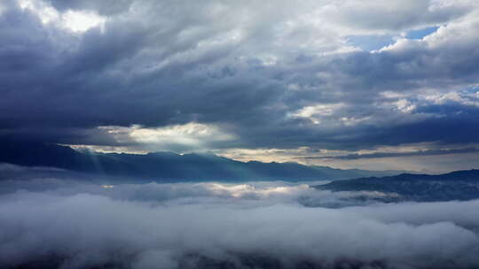 清晨的太阳光透过云层打在山川云雾之上