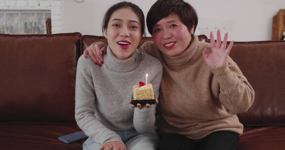 妈妈和女儿在家里看镜头视频聊天庆祝生日