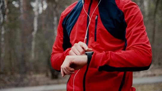 慢跑者在森林中检查智能手表的心率