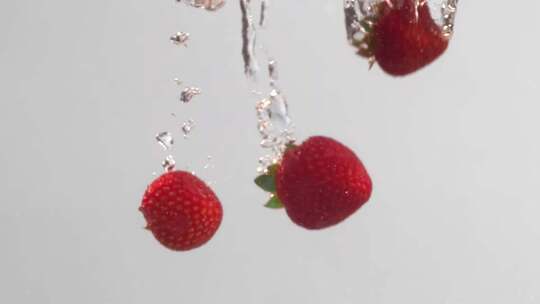 白色背景草莓落入水中