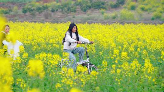 春天少女在油菜花海骑行慢动作