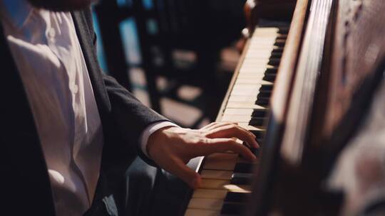 一位男性音乐家在弹钢琴的特写镜头