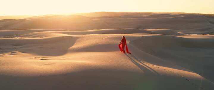 红衣美女行走在沙漠