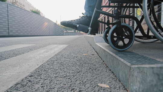 特写轮椅轮子轻轻地从人行道的路边缓缓下降