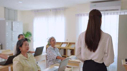 亚洲女教师在语言学校教成熟的学生。