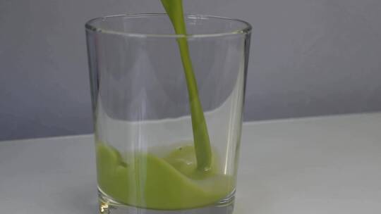 在小玻璃杯里倒入亮绿色抹茶