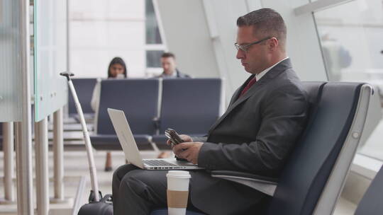 商人在机场使用笔记本电脑