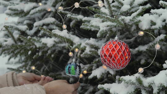 下雪天女人在松树上挂圣诞装饰