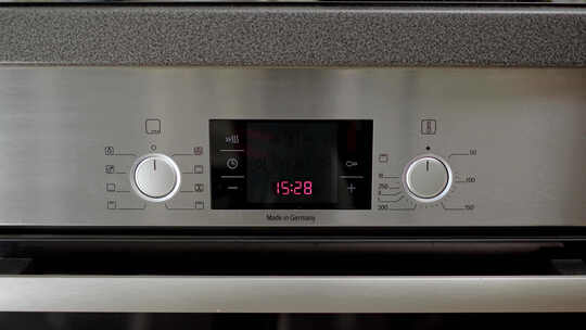 厨师或家庭主妇启动烤箱并将温度设置为180摄氏度