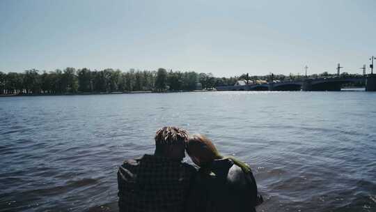 坐在湖边谈恋爱的情侣