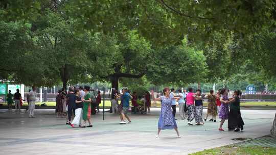 城市公园人文中老年人晨练跳广场舞休闲运动视频素材模板下载