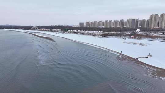 沿海城市被雪覆盖的沙滩及高楼景象