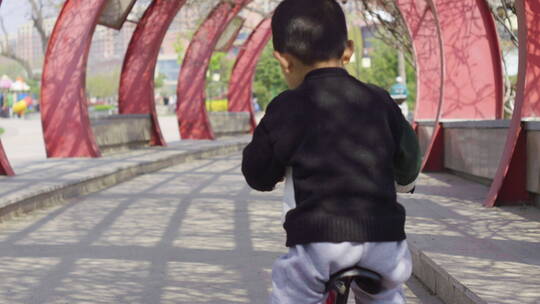 小朋友开心在公园骑自行车玩耍