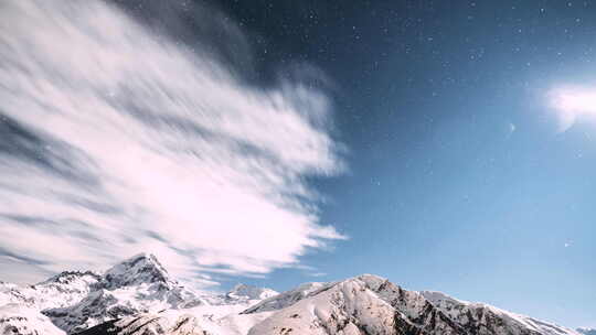 冬夜星空与发光的星星和山顶覆盖着雪