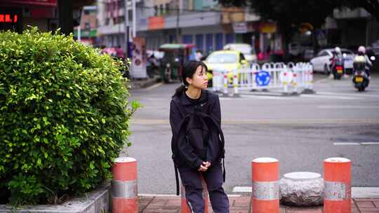 一个流浪的女人孤单的坐在街头柱子上打哈欠