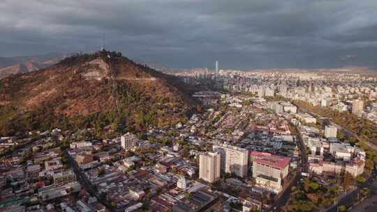 智利日落时圣地亚哥北部城市的塞罗圣克里斯托瓦尔。空中广角拍摄