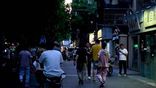 夜晚昏暗街道行人走动的景象