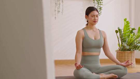 女子坐在瑜伽垫上冥想视频素材模板下载