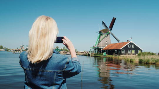 女人在拍摄荷兰风车视频素材模板下载