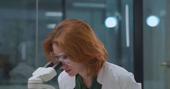女科学家使用显微镜观察化学反应