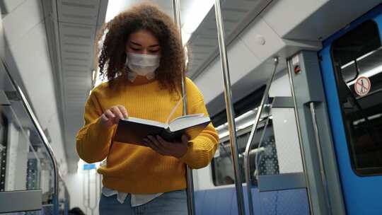 女人在地铁上看书