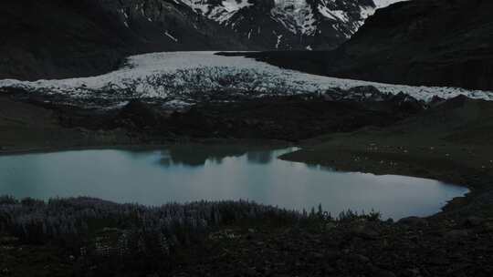 水池和白雪覆盖的山脉附近的冰川形成