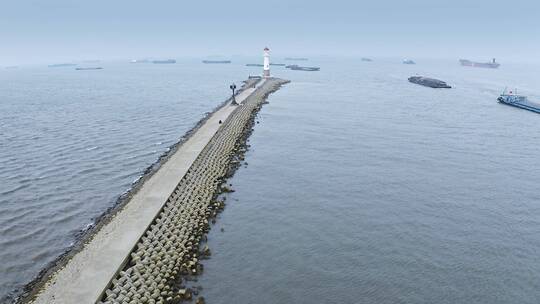 无人机视角航拍海岸堤坝小路与灯塔