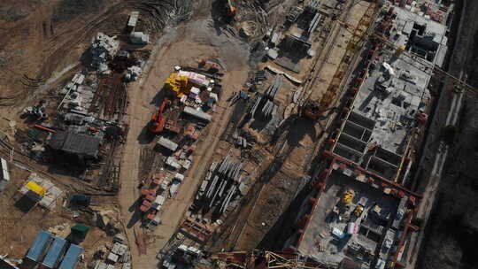 无人机俯视飞越建筑工地。摄像机飞过上层建筑，顶部