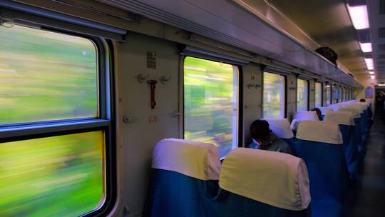 行驶火车车厢窗外自然风景与车内座椅景观