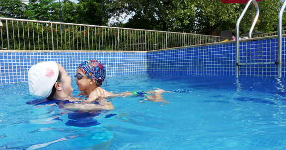 夏天游泳池小男孩和妈妈一起游泳玩耍