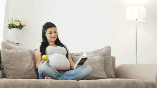 孕妇和她的女儿坐在沙发上