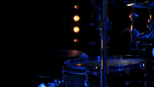 蓝光下舞台上的特写鼓，黄光从后面照亮