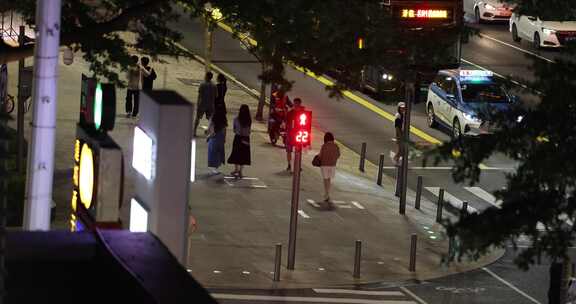 夜晚街道行人等待过马路场景