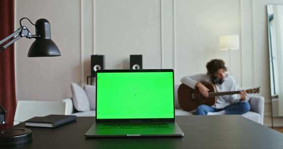 笔记本电脑、绿屏、吉他、书桌