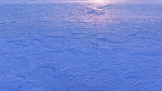 夕阳映射到雪地上的光影