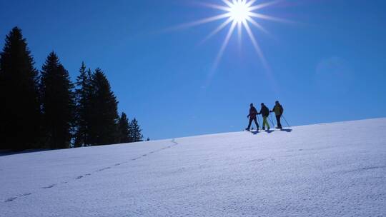 穿着雪地靴走在阳光照射下的雪山上镜头特写