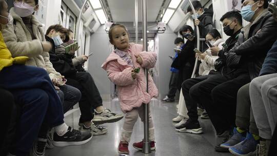 小女孩在地铁玩耍乘客带口罩