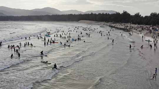 海南三亚后海度假村正在海边冲浪的游客