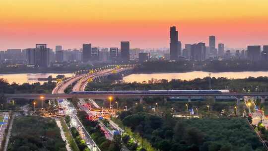 航拍夕阳高铁行驶桥梁河流车流建筑群高楼