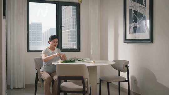 桌边处理蔬菜 孤寡老人在家摘菜叠衣服