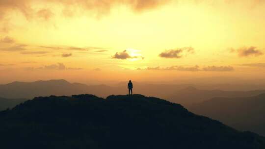 夕阳下站在山顶的男人