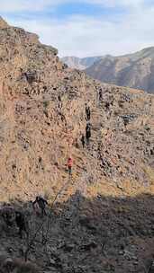 户外登山者在陡峭岩壁上攀爬前行