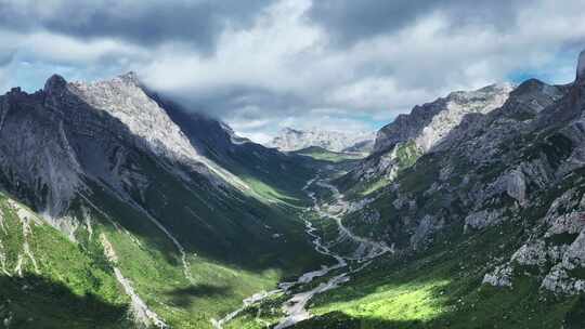 蓝天白云下甘南扎尕那的山脉和山谷中的公路