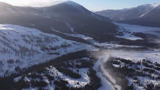 航拍新疆冬季喀纳斯河流晨雾雪山森林雪景