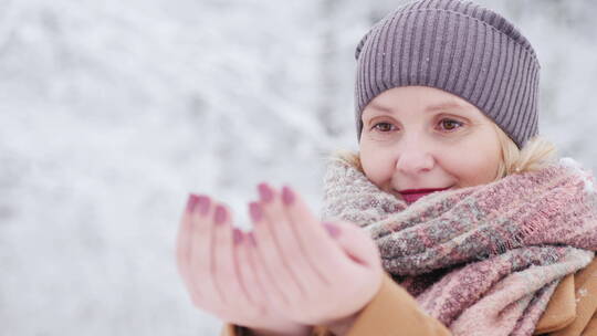 女人用双手接住飘落的雪花视频素材模板下载