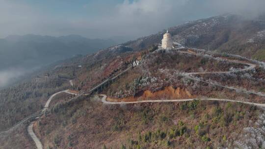 冬季山顶冰雪包裹的高塔和延绵山路高山雾淞