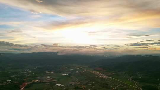 航拍夕阳时分的山脉天空云彩和城镇延时